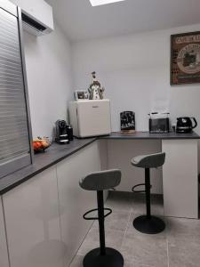 a kitchen with two stools in front of a counter at Angoulême Nord location Chambre indépendante in Champniers