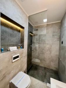 a bathroom with a shower and a toilet and a sink at Capital Hotel Garni in Belgrade