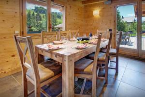 a dining room with a wooden table and chairs at Chalet Alex - OVO Network in Saint-Jean-de-Sixt