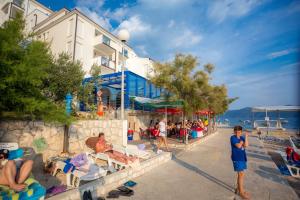 a group of people sitting on chairs at a beach at AG Komarna - Peljesac Bridge Apartments in Komarna