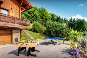 a patio with two ping pong tables in front of a house at Chalet Alex - OVO Network in Saint-Jean-de-Sixt