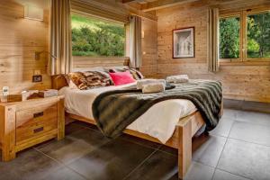 a bedroom with a large bed and a window at Chalet Alex - OVO Network in Saint-Jean-de-Sixt