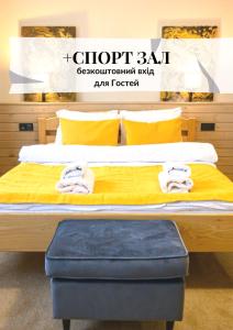 una camera da letto con letto con lenzuola gialle e cuscini gialli di Space Apart Hotel a Luc'k