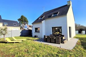 une maison blanche avec des chaises jaunes et une cour dans l'établissement La villa Breizh 'île, à Saint-Gildas-de-Rhuys