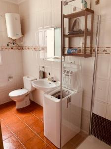 a white bathroom with a toilet and a sink at coqueto apto EILA 100 metros playa WIFI in Famara