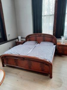 1 dormitorio con 1 cama de madera y 2 mesitas de noche en Ferienwohnung Altes Künstleratelier Weimar, en Weimar