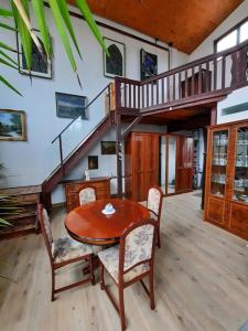 une salle à manger avec une table, des chaises et un escalier dans l'établissement Ferienwohnung Altes Künstleratelier Weimar, à Weimar