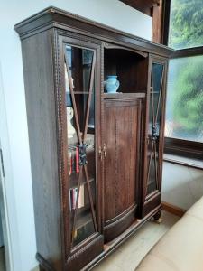 un armario de madera con puertas de cristal en una habitación en Ferienwohnung Altes Künstleratelier Weimar, en Weimar