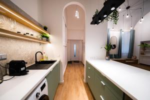 una cocina con armarios verdes y encimeras blancas en Coente Apartments Király 28, en Budapest
