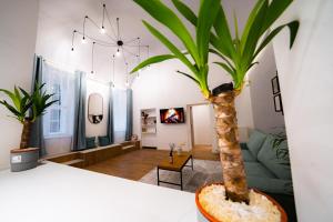 una sala de estar con una palmera en un jarrón en Coente Apartments Király 28, en Budapest