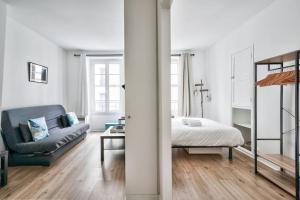 Nice apartment at 10 min from Bastille في باريس: غرفة معيشة مع سرير وأريكة
