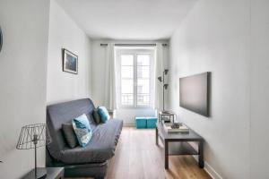 Nice apartment at 10 min from Bastille في باريس: غرفة معيشة مع أريكة وطاولة