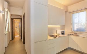 a white kitchen with a sink and a microwave at Sea Holidays Apartment in Marina di Pietrasanta