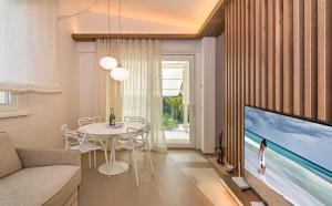 un soggiorno con grande TV e tavolo di Sea Holidays Apartment a Marina di Pietrasanta
