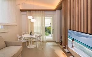 a living room with a large tv and a table at Sea Holidays Apartment in Marina di Pietrasanta