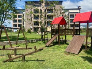 un parque con parque infantil de madera frente a un edificio en Hermoso departamento en Yerba Buena en San Miguel de Tucumán