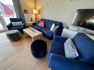 sala de estar con sofás azules y TV en Anker 39 en Plau am See