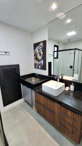 a bathroom with a sink and a mirror at Estúdio Ultra Luxo com Vista Panorâmica in Campo Grande
