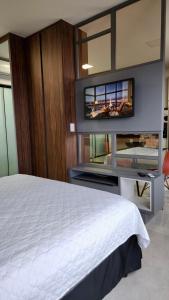 um quarto com uma cama e uma televisão na parede em Estúdio Ultra Luxo com Vista Panorâmica em Campo Grande