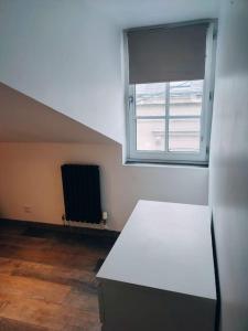 une chambre vide avec une fenêtre et un réfrigérateur dans l'établissement Maison chaleureuse située à Saumur, à Saumur