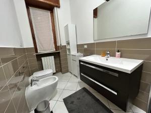 ein Badezimmer mit einem Waschbecken, einem WC und einem Spiegel in der Unterkunft Residenza Ancora - Centro - Zona Ospedale in Piacenza