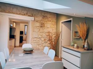 索米爾的住宿－Maison chaleureuse située à Saumur，一间带桌子和白色椅子的用餐室