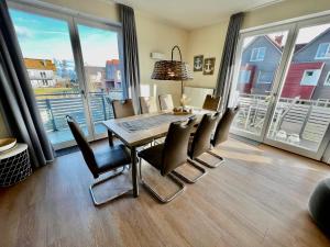 uma sala de jantar com mesa, cadeiras e janelas em Anker 39 em Plau am See