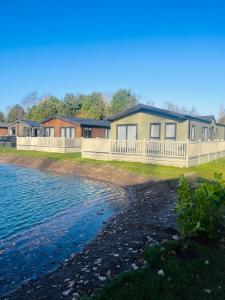 a row of houses on the shore of the water at Bridgewater Lodge with Hot Tub in York