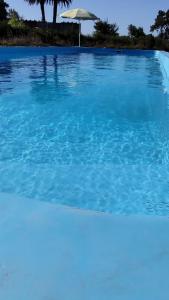 una piscina de agua azul y una sombrilla en Bahía de cimarrones en 
