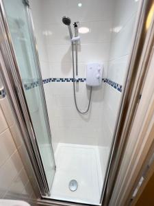 a bathroom with a shower with a glass door at Princes Court, Sea Road in Bournemouth