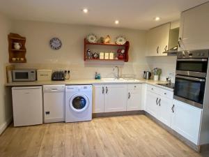 a kitchen with a washing machine and a washer at Far Hill Cottage in Wyck Rissington