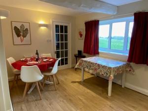 a dining room with a table and chairs and a window at Far Hill Cottage in Wyck Rissington +11 photos