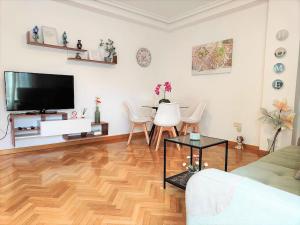 a living room with a television and a wooden floor at APARTAMENTOS TURISTICOS SEVIRO Madrid in Madrid