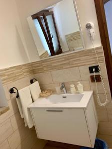 y baño con lavabo blanco y espejo. en Agriturismo Sant'Agata, en Piana degli Albanesi