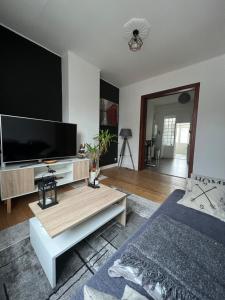 a living room with a large flat screen tv at L Escapade Urbaine in Brussels