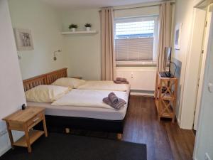 ein kleines Schlafzimmer mit 2 Betten und einem Fenster in der Unterkunft Haus Regenpfeifer in Büsum