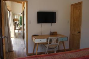 a room with a desk with a television and a mirror at Acogedora casa a pasos de la playa-Couzy house next to the beach in La Serena