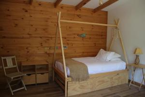 a bedroom with a bed with a wooden wall at Acogedora casa a pasos de la playa-Couzy house next to the beach in La Serena