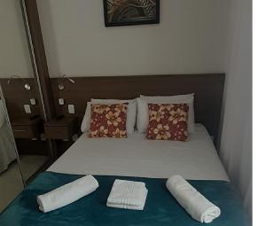 1 cama con 2 almohadas y 2 toallas. en Jacques Pilon estúdio 425, en São Paulo