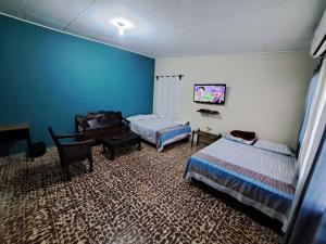 Habitación con 2 camas y escritorio. en Hostal Lima Verde en La Lima