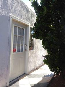 a white door of a white building with a window at Cozy apartment in an Ecotourism El Tascate Rancho in Cuauhtémoc