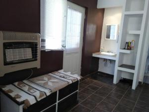 - une petite salle de bains avec un lit et un lavabo dans l'établissement Cozy apartment in an Ecotourism El Tascate Rancho, à Cuauhtémoc