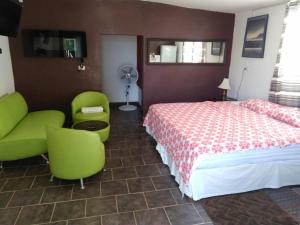 - une chambre avec un lit, des chaises et un ventilateur dans l'établissement Cozy apartment in an Ecotourism El Tascate Rancho, à Cuauhtémoc
