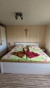 a bedroom with a bed with a bow on it at Landhaus "Kühler Morgen", Komfortable 65 qm FeWo mit gehobener Ausstattung, Garten, baby- und kindgerecht in Saalburg-Ebersdorf