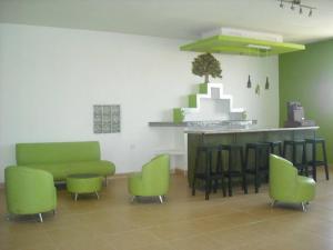 a waiting room with green chairs and a bar at Cozy apartment in an Ecotourism El Tascate Rancho in Cuauhtémoc