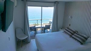a bedroom with a bed and a view of the ocean at Dei Templi Apart Hotel in Viña del Mar