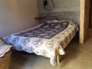Una cama con una manta blanca y negra. en La rose bleue (2) en Olmeto