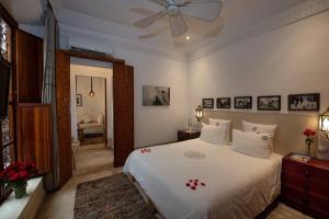 una camera con letto bianco e ventilatore a soffitto di Riad Dar Justo Hotel Boutique & Spa a Marrakech