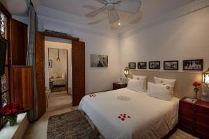 a bedroom with a white bed and a ceiling fan at Riad Dar Justo Hotel Boutique & Spa in Marrakesh