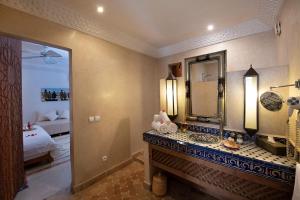 łazienka z umywalką, lustrem i łóżkiem w obiekcie Riad Dar Justo Hotel Boutique & Spa w Marakeszu